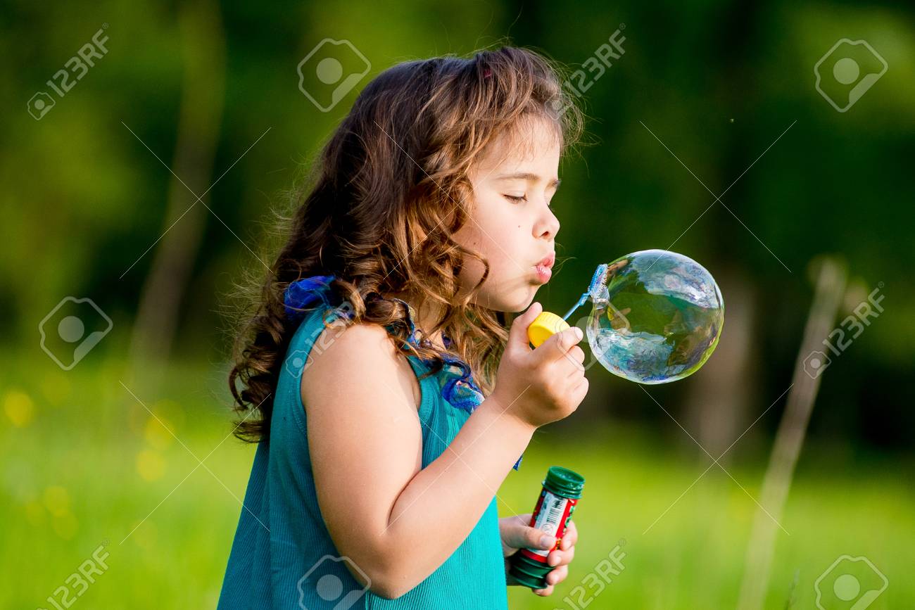 小さな女の子は 草の上に座ってシャボン玉を吹きます 2 人の姉妹 の写真素材 画像素材 Image