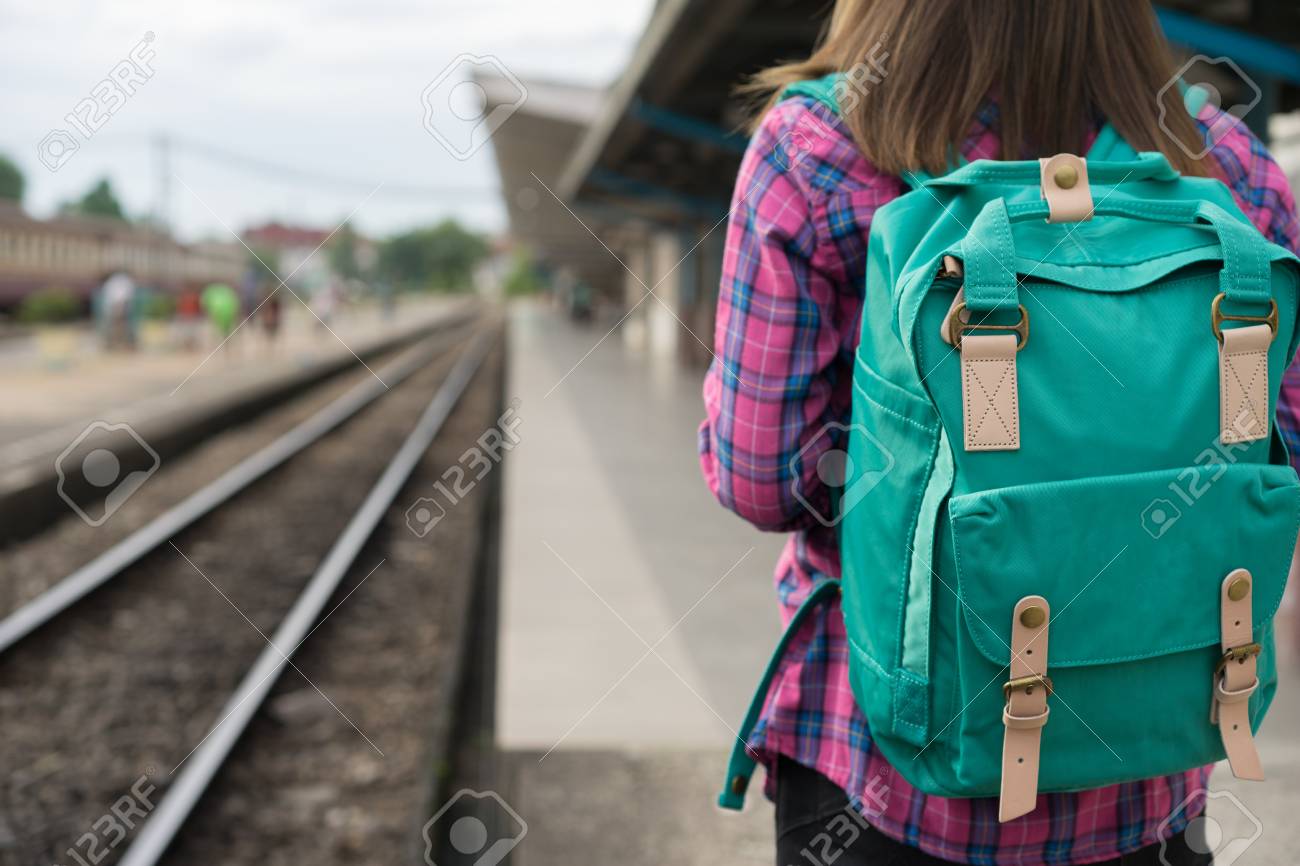 Traveler woman walking and waits train on railway platform, Sun light flare, Selective focus - 104435654 Traveler woman walking and waits train on railway platform, Sun light flare, Selective focus - 104435654