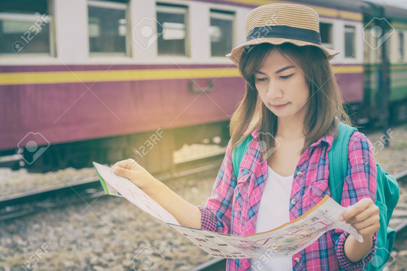 Young woman traveler with backpack and hat at the train station and looking on the map for plan to travel, Travel concept - 104430536 Young woman traveler with backpack and hat at the train station and looking on the map for plan to travel, Travel concept - 104430536
