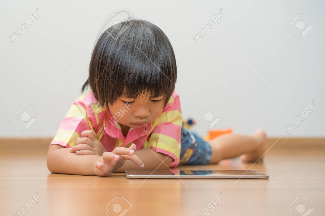 Portrait of child playing with digital tablet at home. - 104430260 Portrait of child playing with digital tablet at home. - 104430260