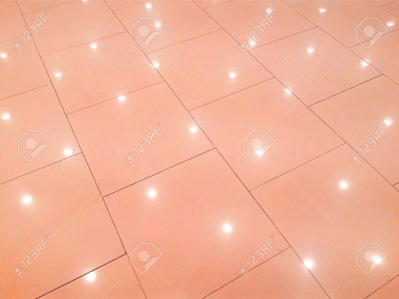 The Background Is A Tile Floor With A Light Shining Down Below