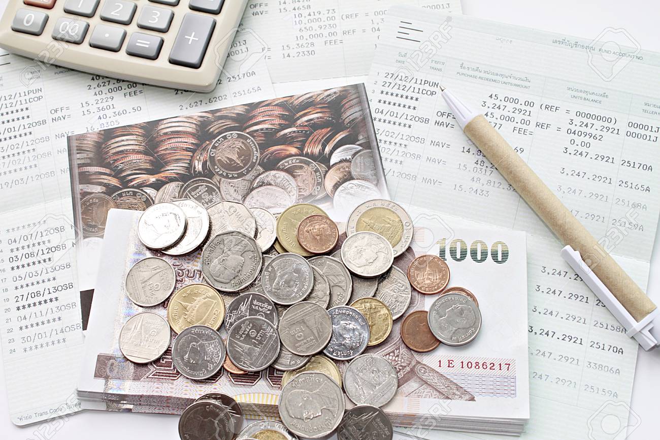 Business, finance, saving money, taxes or accounting concept : Top view or flat lay of coins, cash money, calculator and pen on savings account book or financial statements - 126599897 Business, finance, saving money, taxes or accounting concept : Top view or flat lay of coins, cash money, calculator and pen on savings account book or financial statements - 126599897