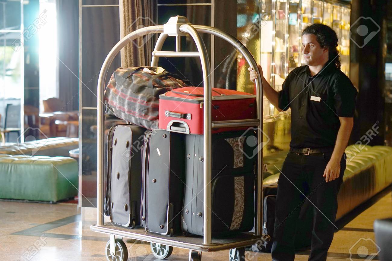 Closeup Muchas Maletas En Carrito De Equipaje De Hotel Moviéndose Botones. Portero De Equipaje Botones Que Lleve La Maleta De Los Huéspedes Con Furgoneta A La Habitación Del Hotel. Trolley