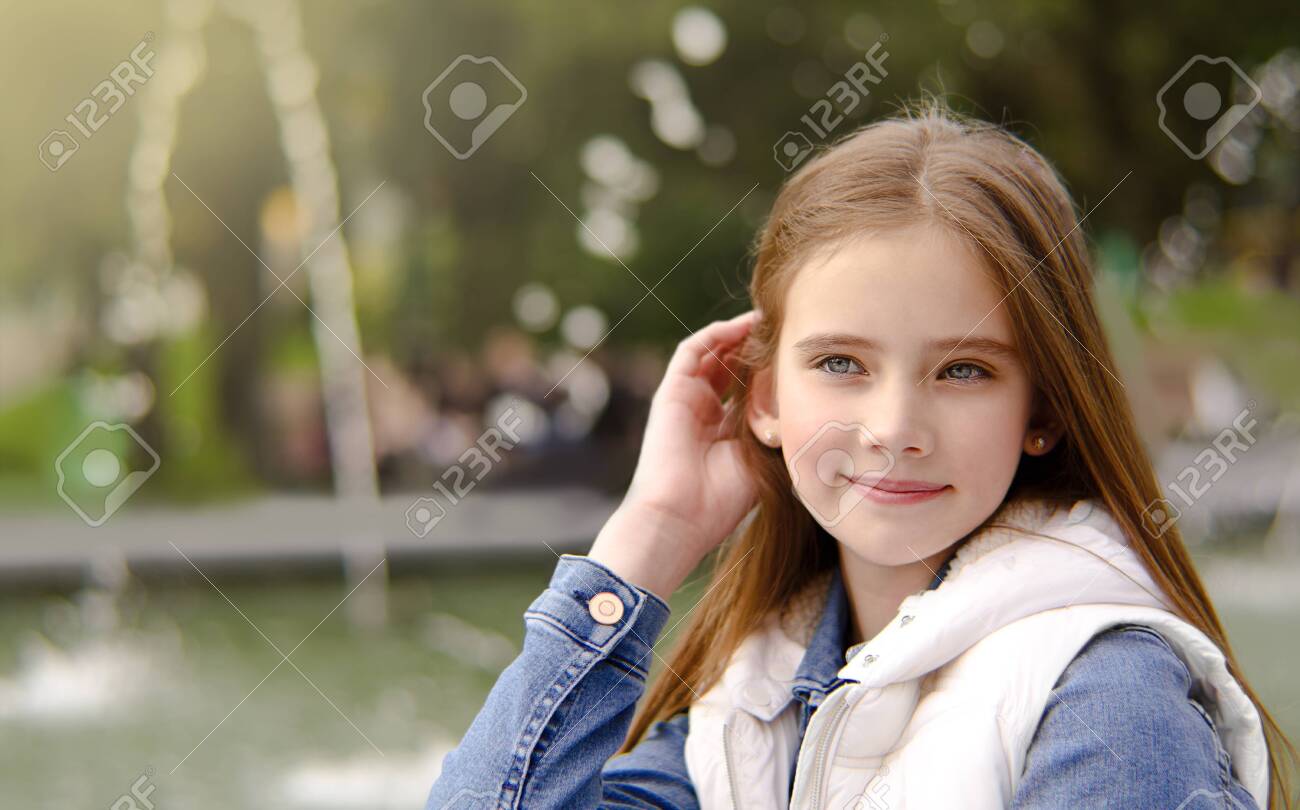 Retrato Ao Ar Livre De Uma Menina De 8 Anos Bonito. Uma Menina Sorrindo Para  A Câmera. Foto Royalty Free, Gravuras, Imagens e Banco de fotografias.  Image 174338419