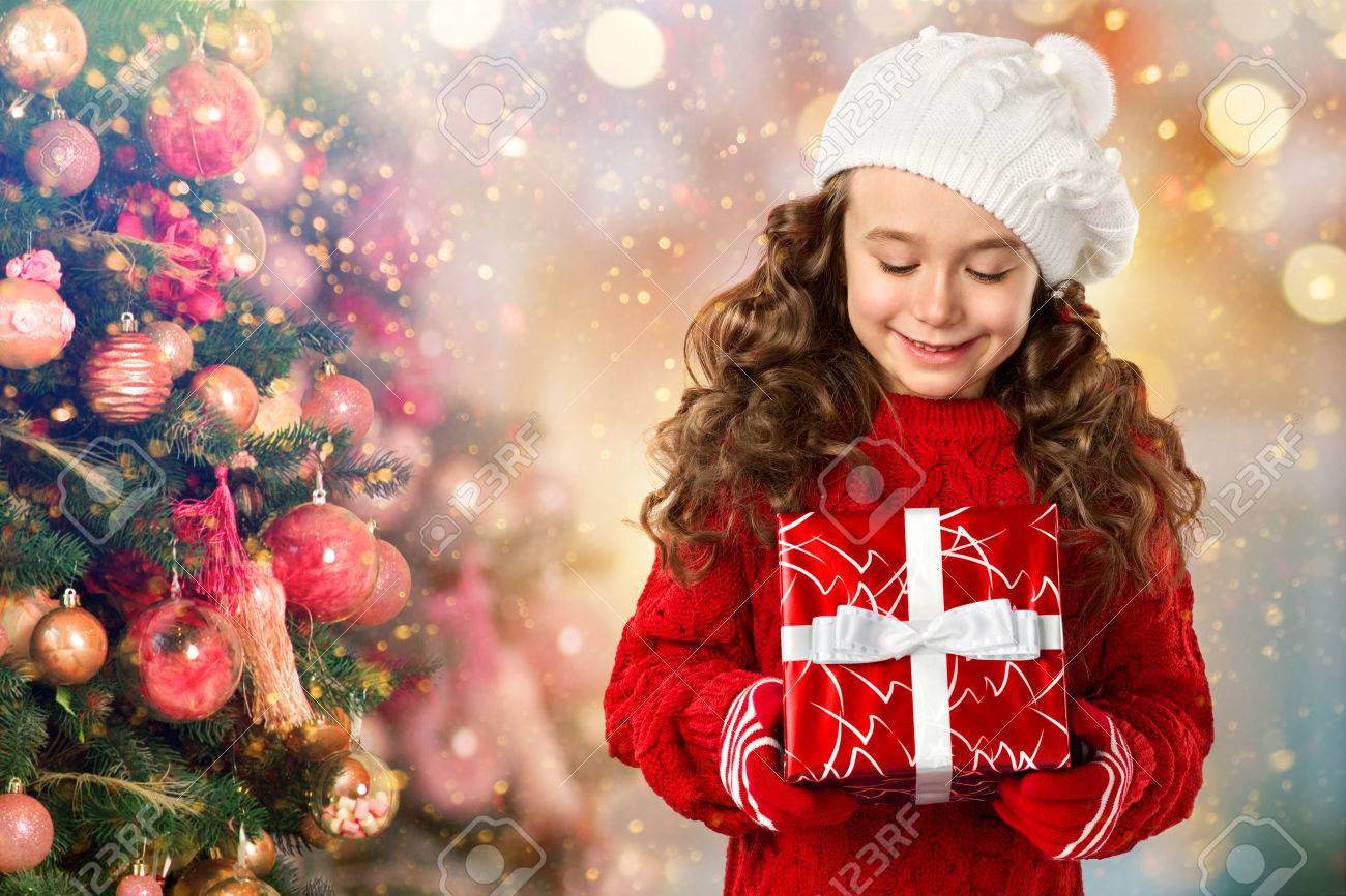 メリー クリスマスと幸せな新年の休日 ギフト クリスマス ツリーの近くで幸せな小さな女の子 クリスマス セール の写真素材 画像素材 Image