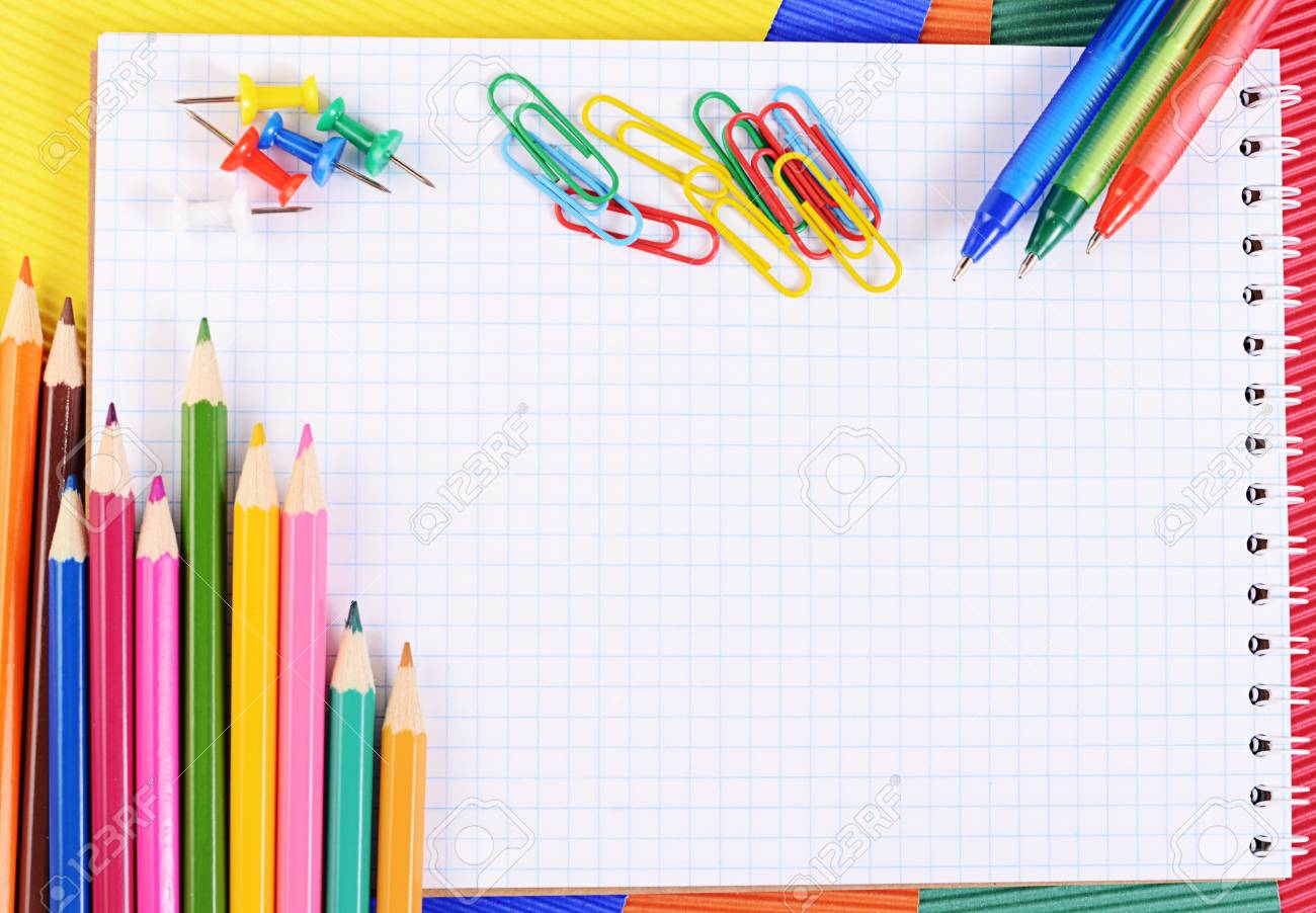color pencils on multi colored paper with notebook stock photo