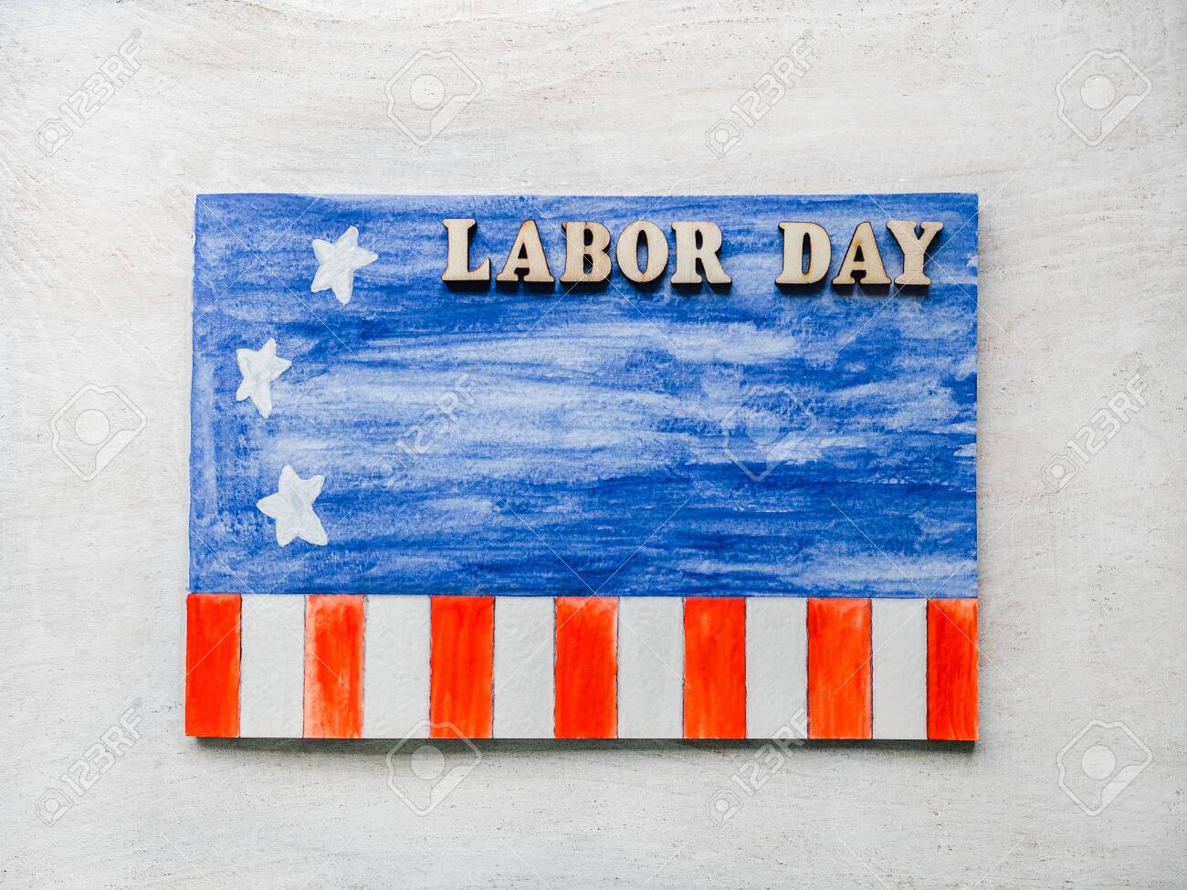 LABOR DAY. Notepad, American flag pattern and wooden letters of the alphabet on a white table. Close-up. Bright photo and space for your inscriptions. Congratulations to relatives, friends, colleagues - 122820959 LABOR DAY. Notepad, American flag pattern and wooden letters of the alphabet on a white table. Close-up. Bright photo and space for your inscriptions. Congratulations to relatives, friends, colleagues - 122820959