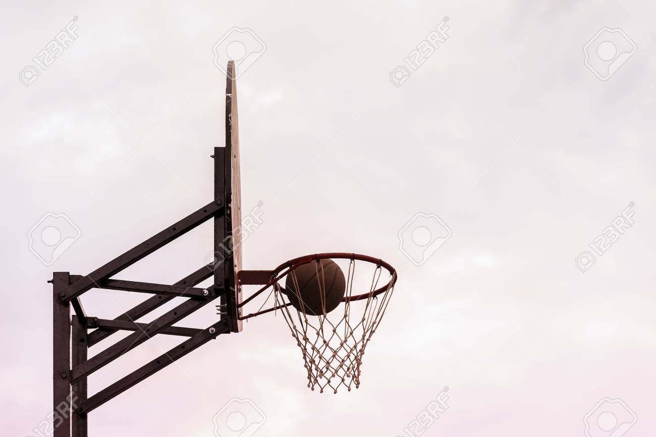 basketball shield ball going through basket on background of