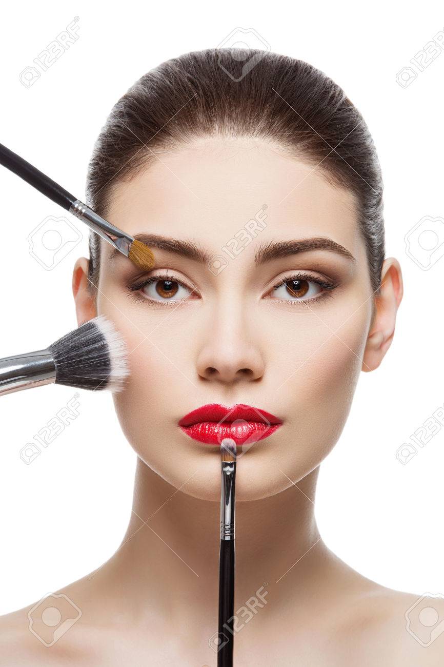 Closeup portrait of beautiful young woman with makeup brushes. Red lips. Isolated over white background. - 49142021 Closeup portrait of beautiful young woman with makeup brushes. Red lips. Isolated over white background. - 49142021