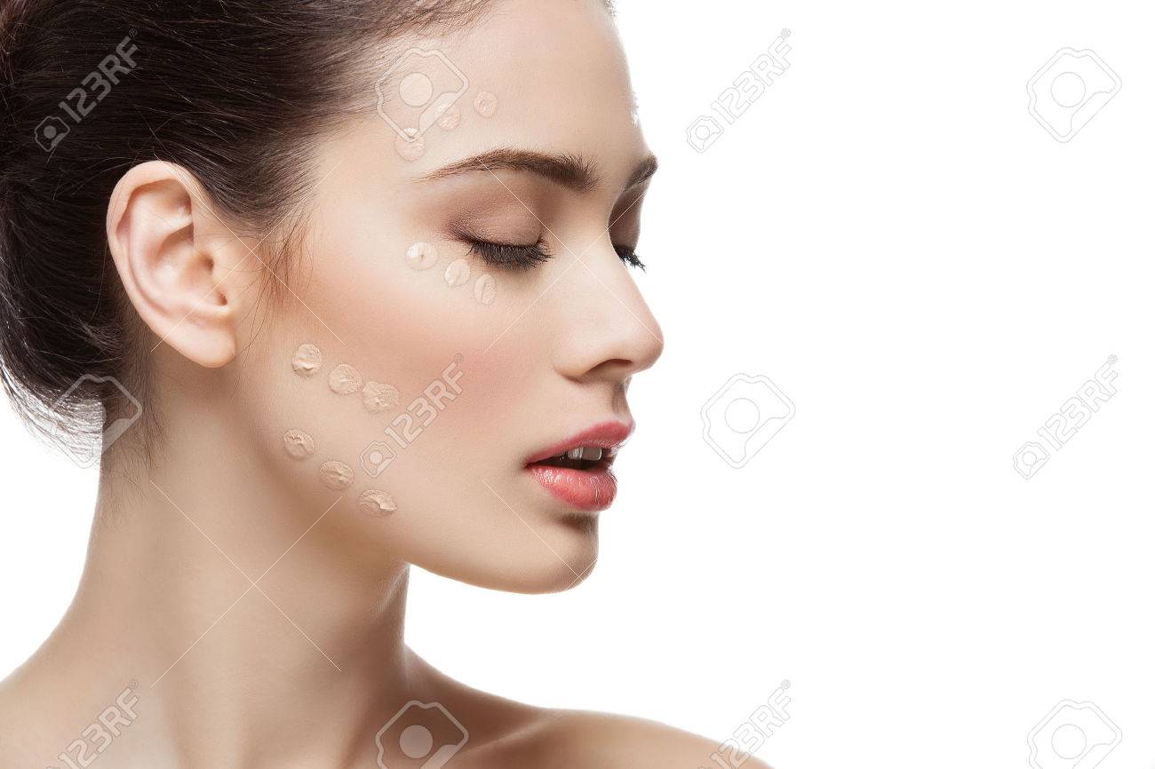 Beautiful young woman with foundation cream on face. Beauty shot. Isolated over white background. Copy space. - 52240426 Beautiful young woman with foundation cream on face. Beauty shot. Isolated over white background. Copy space. - 52240426