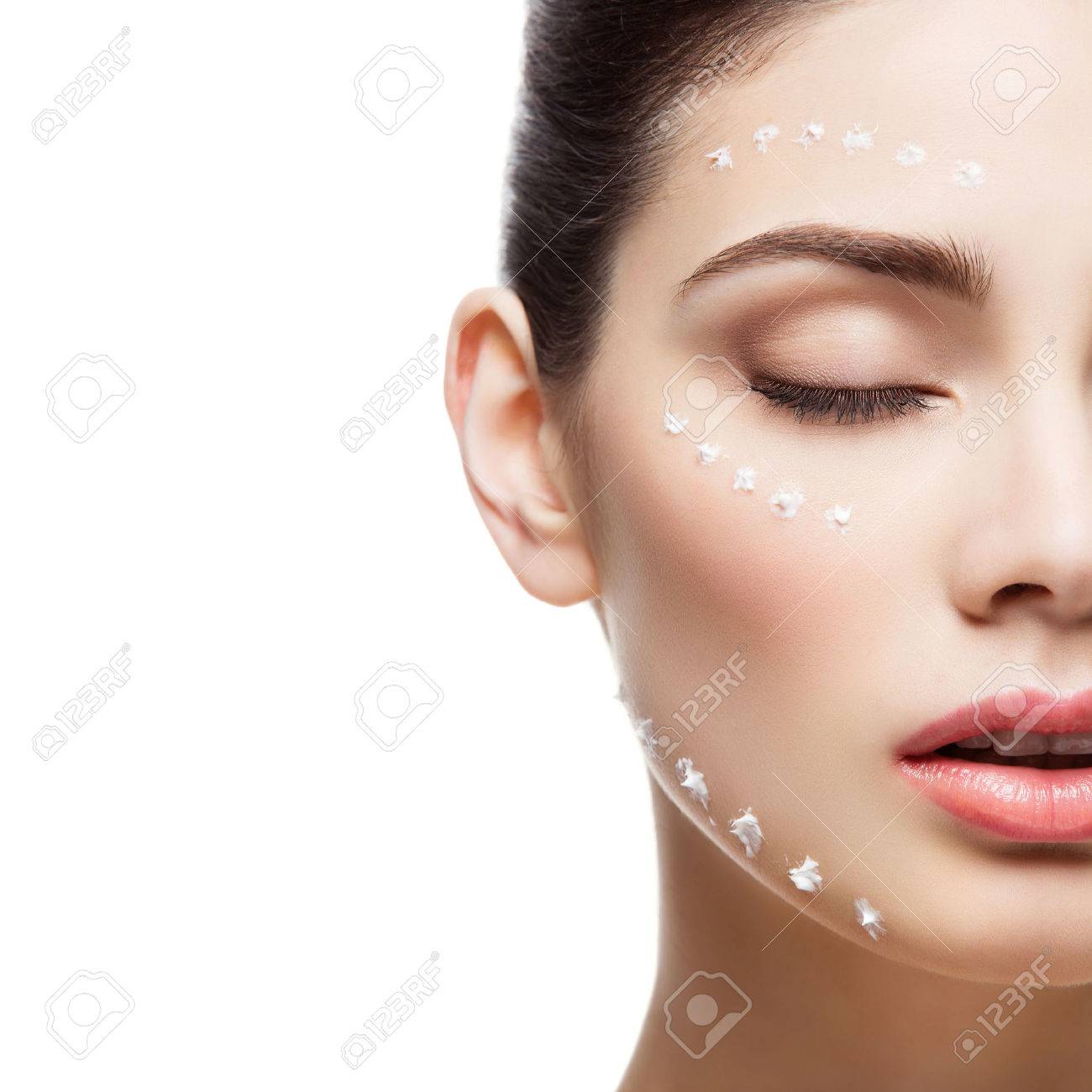 Beautiful young woman with moisturizing cream dots on face. Isolated over white background. Copy space. Square composition. - 55740326 Beautiful young woman with moisturizing cream dots on face. Isolated over white background. Copy space. Square composition. - 55740326