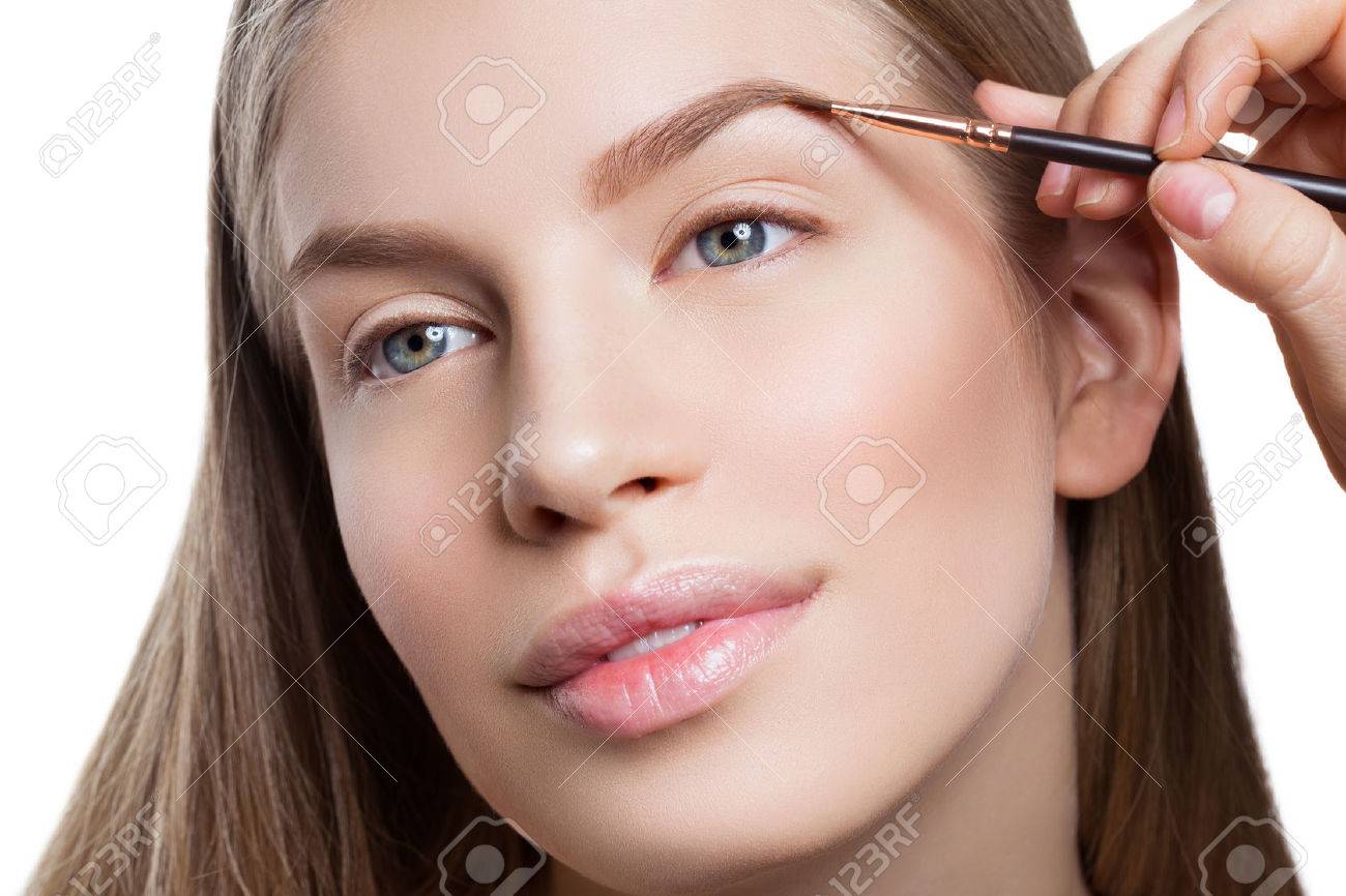 Beautician correcting eyebrows form on beautiful woman face. Beauty shot. Close-up. - 56937646 Beautician correcting eyebrows form on beautiful woman face. Beauty shot. Close-up. - 56937646