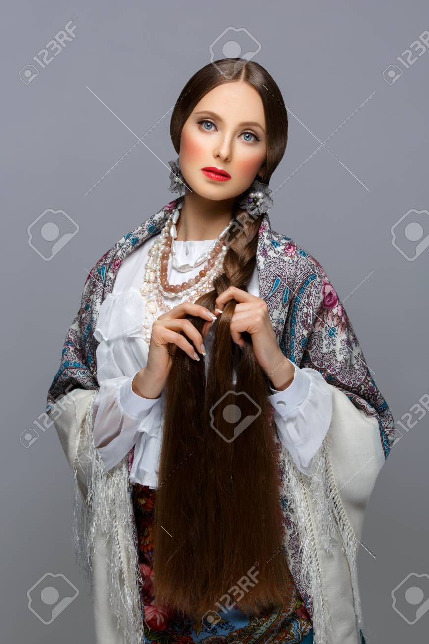 伝統的なショールで非常に長い三つ編みで美しい若いロシア人女性 赤い唇 グレーの背景 の写真素材 画像素材 Image