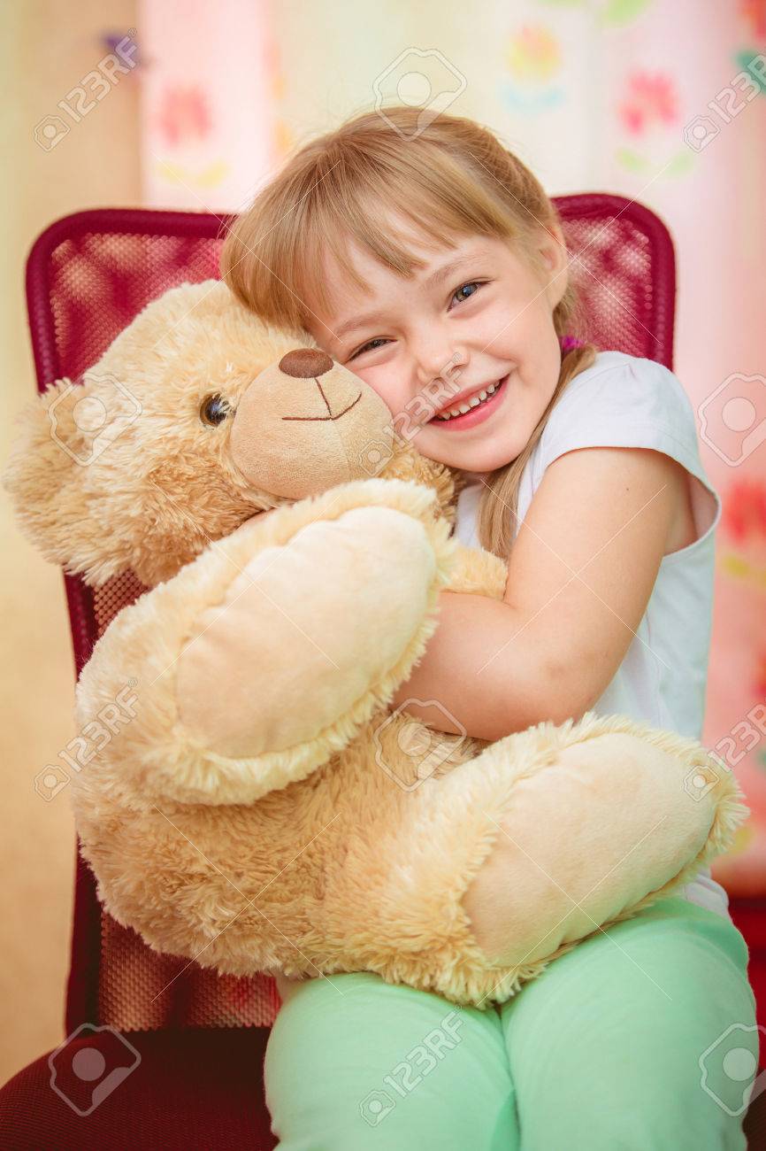 little girl hugging teddy bear