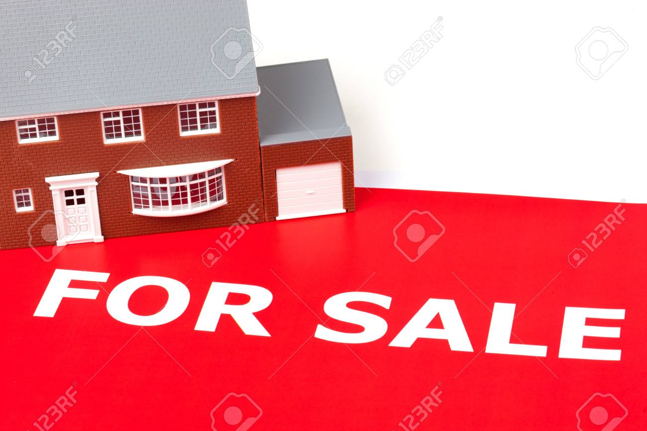 house sitting on a large red for sale sign stock photo picture and large for sale sign