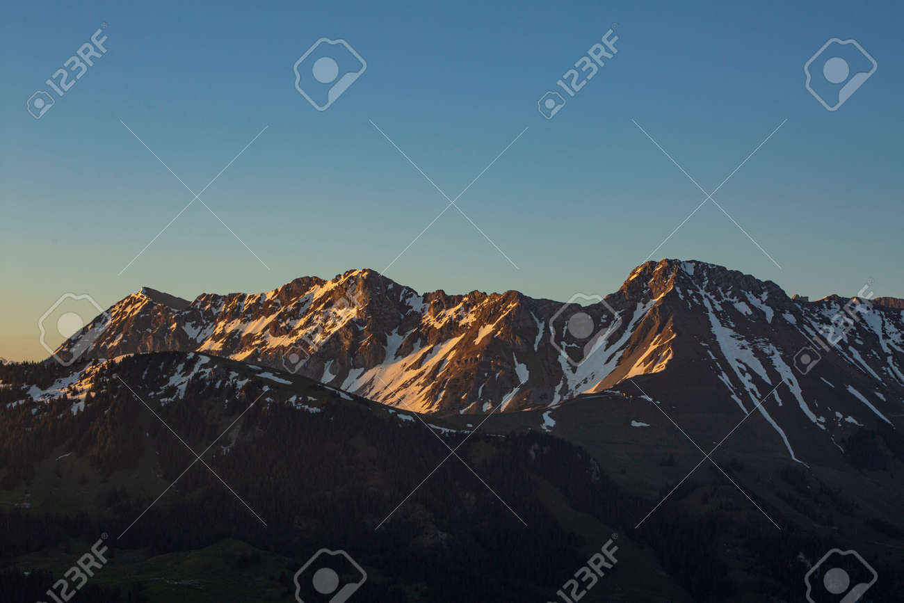 Sunrise over Friborg alps in Switzerland. Sunny blue sky. - 170452054 Sunrise over Friborg alps in Switzerland. Sunny blue sky. - 170452054