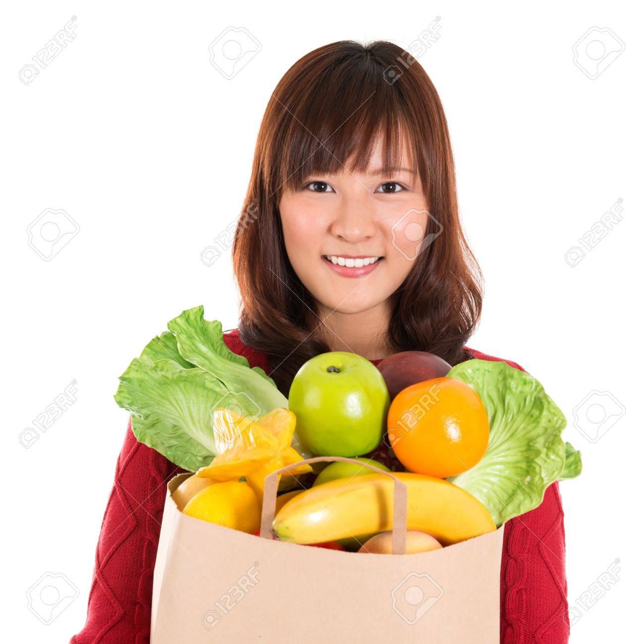Compra en el supermercado feliz. Sonriente joven mujer con bolsa de papel llena de comestibles asiáticos aislados en blanco. Compra en el supermercado feliz. Sonriente joven mujer con bolsa de papel llena de comestibles asiáticos aislados en blanco.