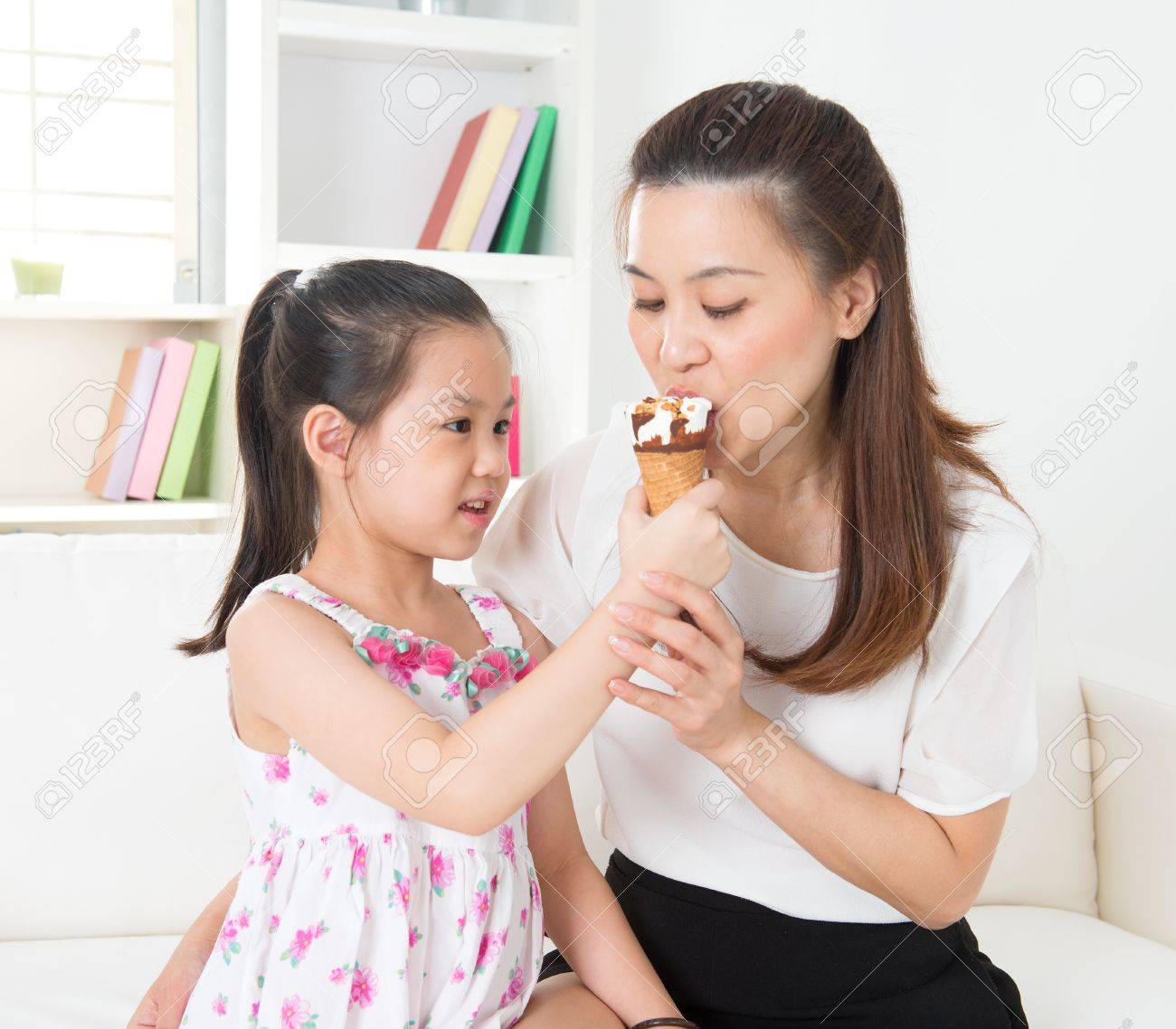 アイス クリームを食べる 幸せなアジア家族が自宅でアイスクリームを食べるします 美しい子供授乳母 の写真素材 画像素材 Image