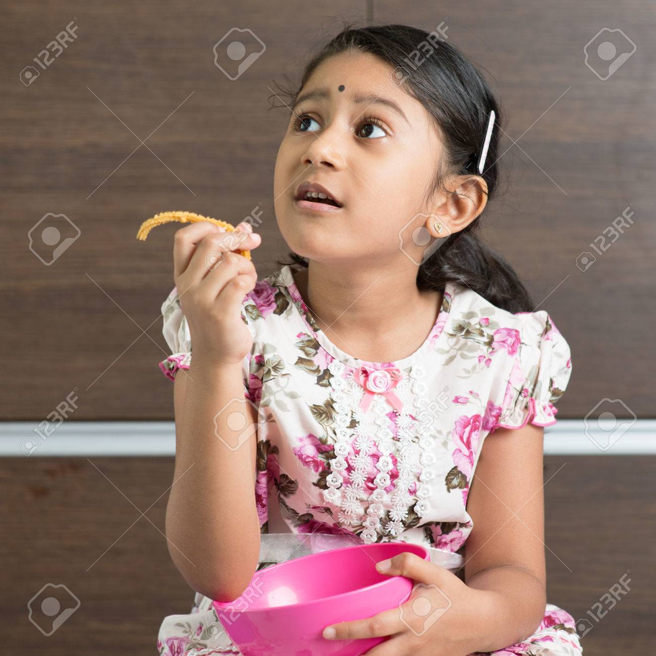 かわいいインドの女の子は 伝統的なスナック Murukku を食べるします の写真素材 画像素材 Image