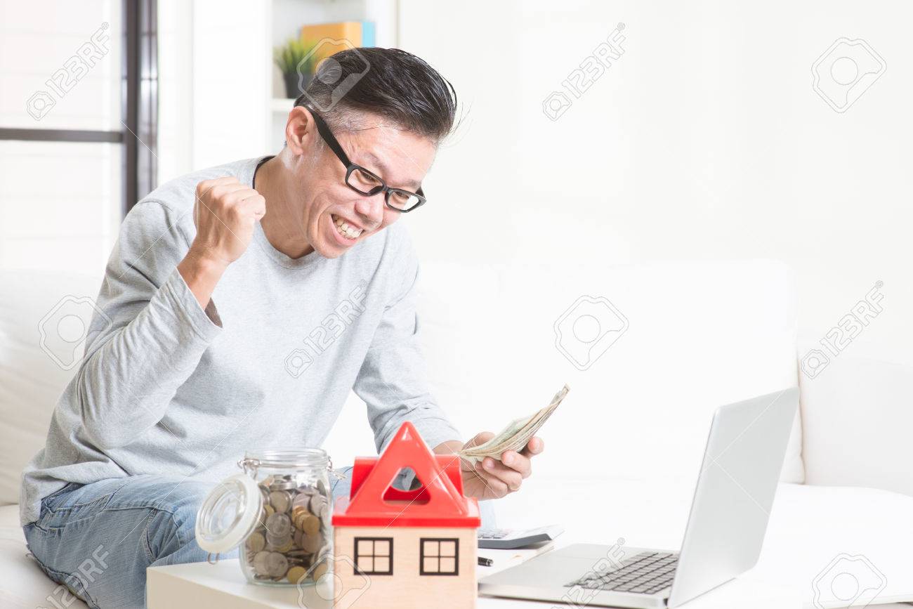 Portrait of happy 50s mature Asian man counting on money and smiling. Saving, retirement, retirees financial planning concept. Family living lifestyle at home. - 51835388 Portrait of happy 50s mature Asian man counting on money and smiling. Saving, retirement, retirees financial planning concept. Family living lifestyle at home. - 51835388