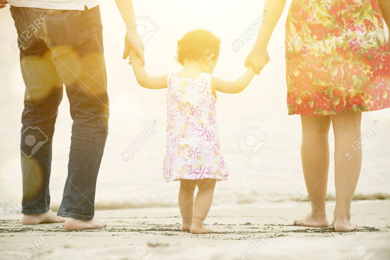 Happy Asian family outdoor activity, holding hands together walking on sand seaside in sunset during vacations. - 70563422 Happy Asian family outdoor activity, holding hands together walking on sand seaside in sunset during vacations. - 70563422