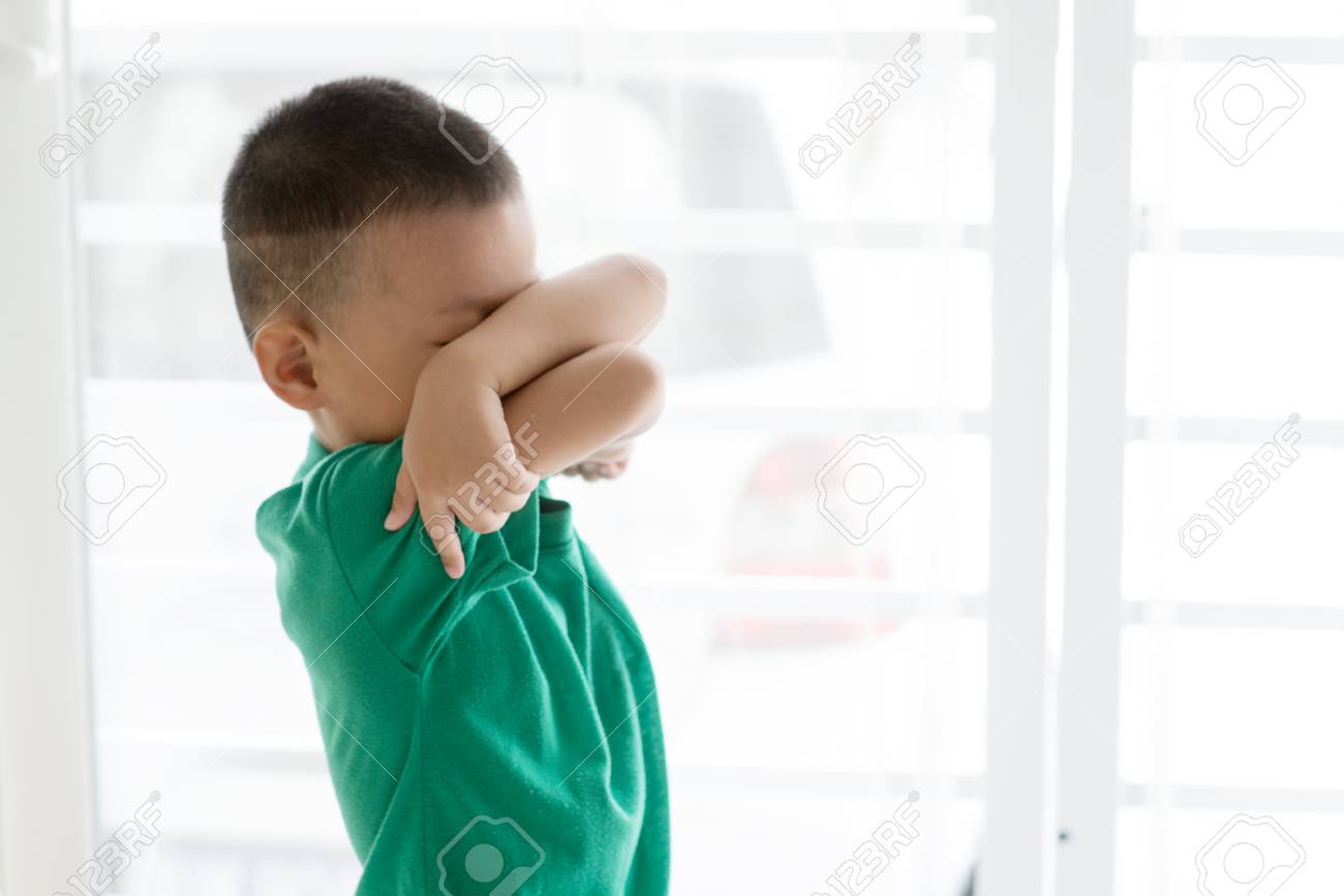 Young child at home. Playful Asian boy covering his face. - 98826249 Young child at home. Playful Asian boy covering his face. - 98826249