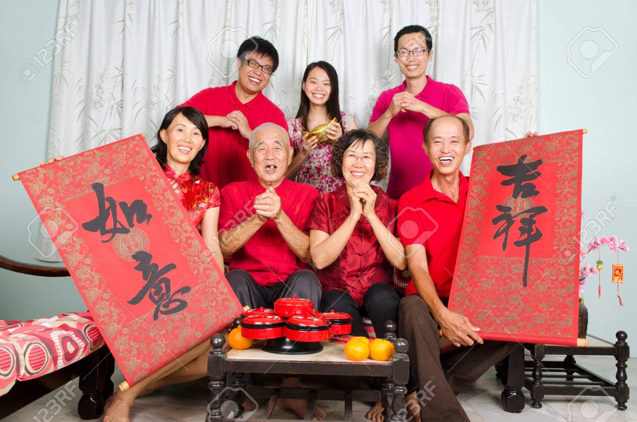 Asian family celebrate chinese new year, family member hold bunting with the word of "auspicious" and "wishful" in chinese character - 50313015 Asian family celebrate chinese new year, family member hold bunting with the word of "auspicious" and "wishful" in chinese character - 50313015