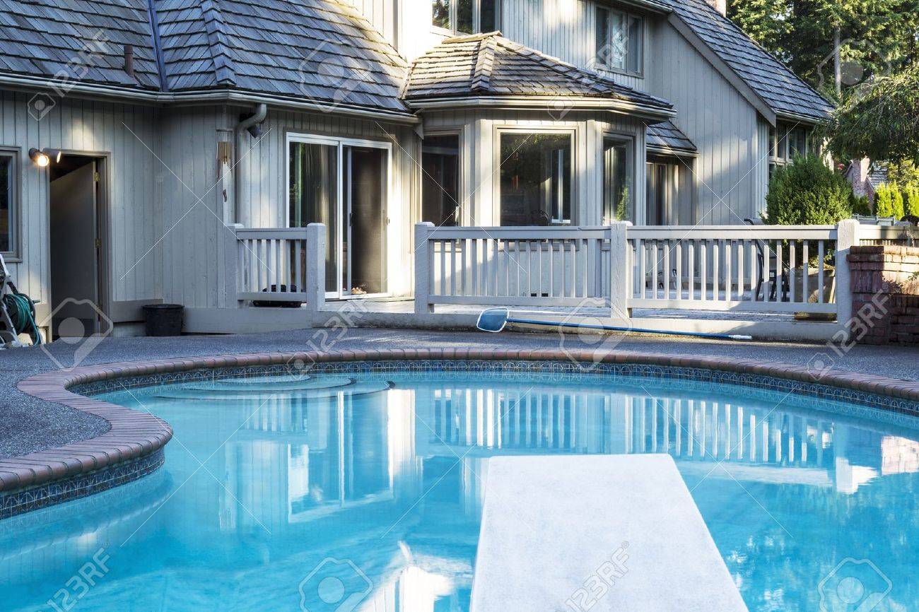 Heated Outdoor Swimming Pool With Large Home In Background With Stock Photo Picture And Royalty Free Image Image 14345334