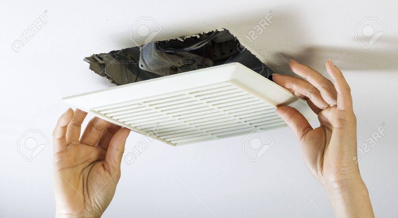 Close Up Horizontal Photo Of Female Hands Removing Bathroom Fan