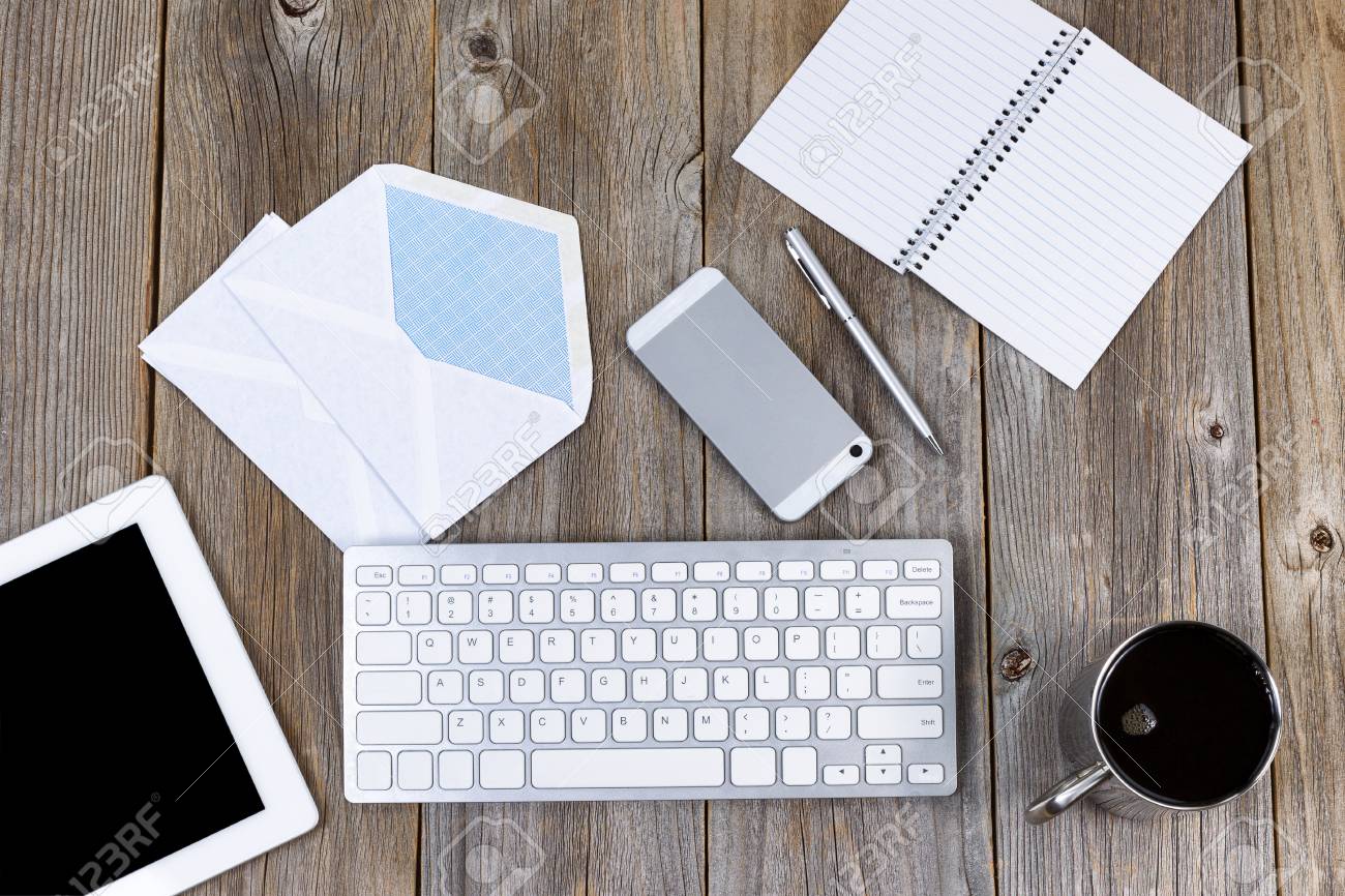 High Angled View Of Working Desktop With Cell Phone Pen Paper