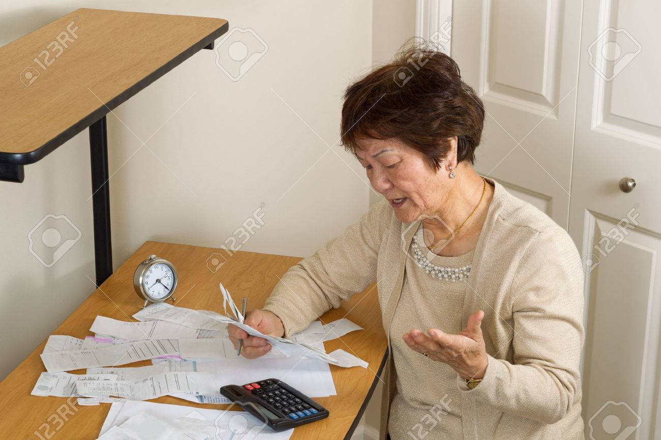 Senior woman upset at her bills. In debt concept. - 50226964 Senior woman upset at her bills. In debt concept. - 50226964