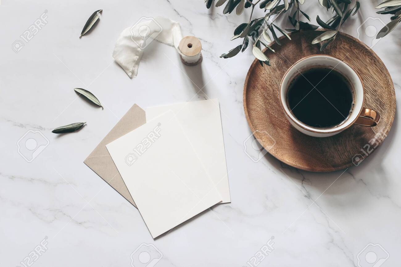Summer wedding stationery mock-up scene. Blank greeting cards, wooden plate, envelope, ribbon, cup of coffee and olive branches. White marble stone table background. Feminine flat lay, top view. - 142609580 Summer wedding stationery mock-up scene. Blank greeting cards, wooden plate, envelope, ribbon, cup of coffee and olive branches. White marble stone table background. Feminine flat lay, top view. - 142609580