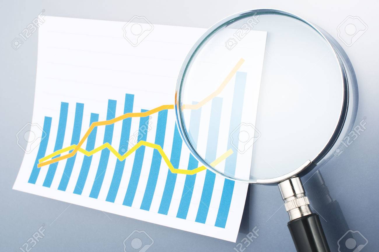 researching and analyzing data with magnifying glass graph and analyzing data