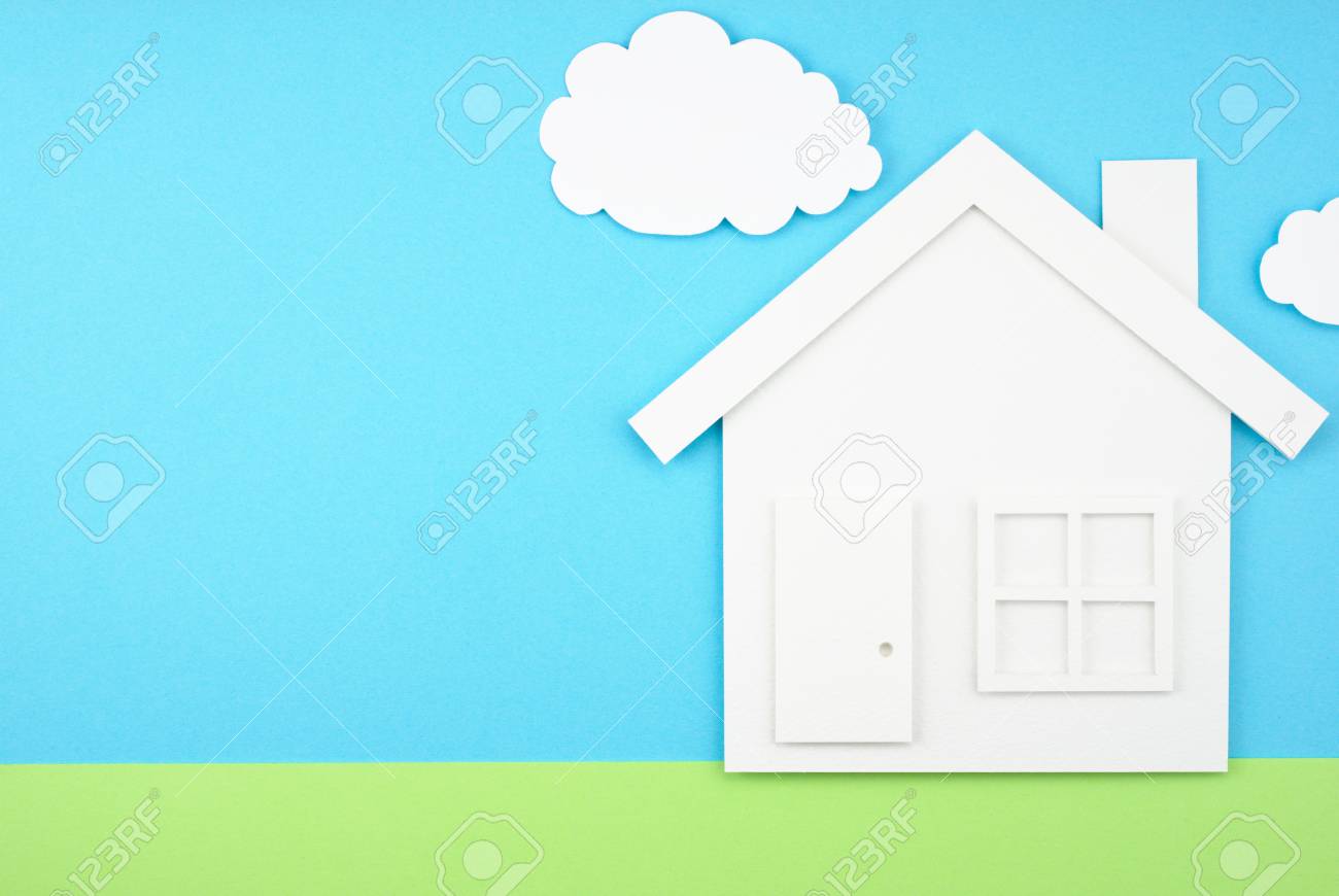 house shaped paper cutout on sky and grass field made of paper paper house cut out