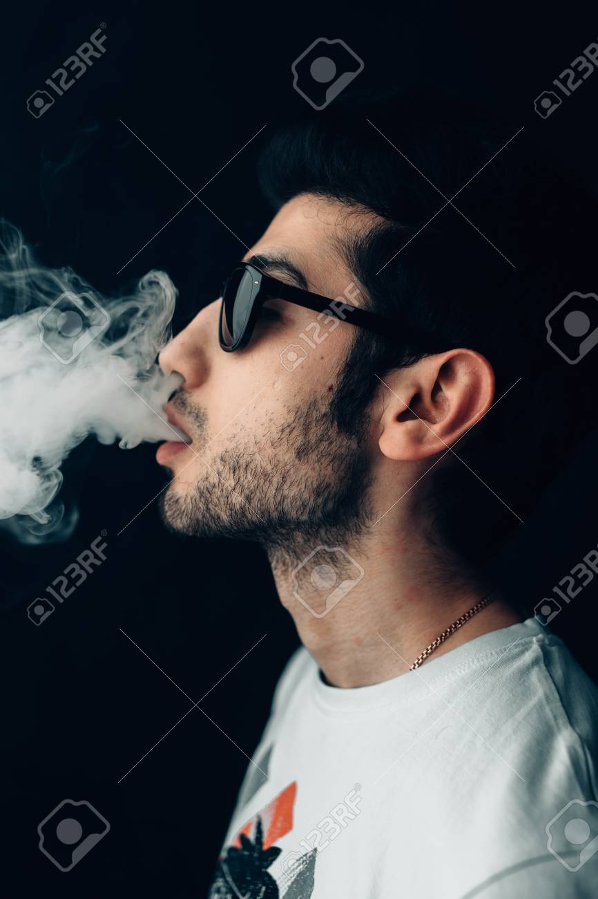 Young Cool Guy In Sunglasses Exhales A Cloud Of Smoke Vertical Studio Portrait In Profile Close Up Stock Photo Picture And Royalty Free Image Image