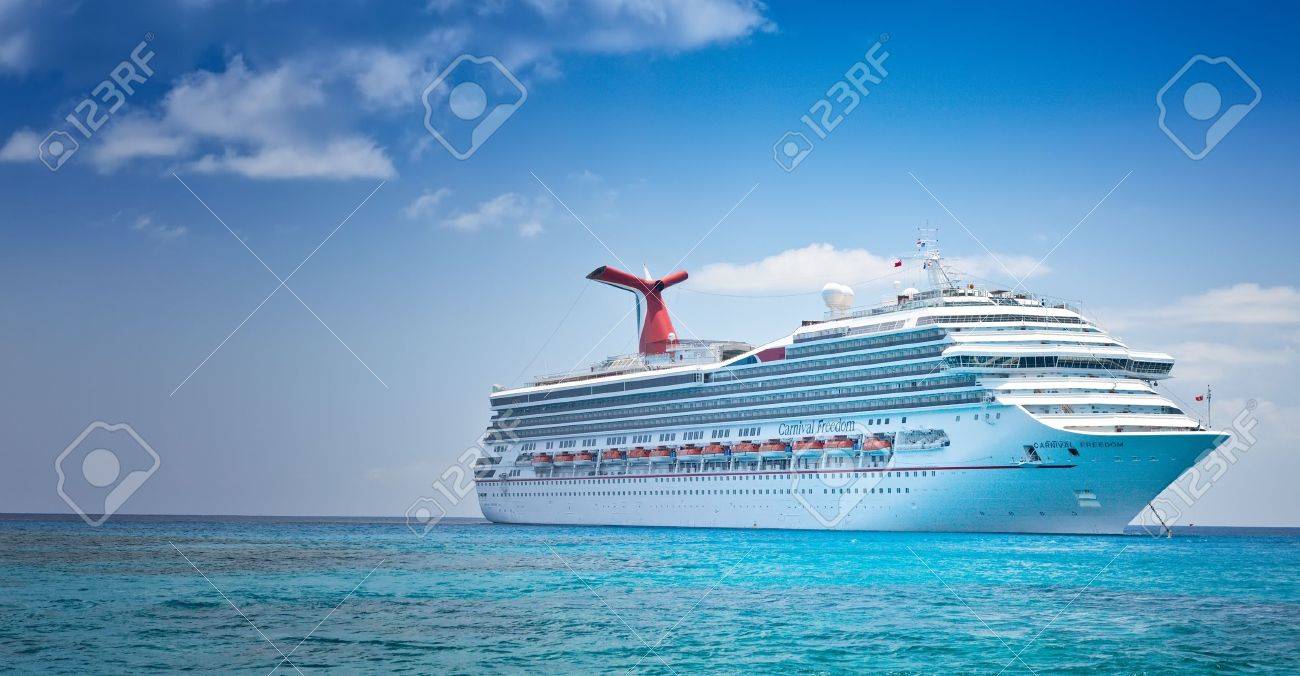 Grand Cayman, Cayman Islands - July 13, 2011: Carnival's Ship, Carnival Freedom, anchored off the coast of Grand Cayman. Passengers have to be tendered to the island for day excursions. - 22459579 Grand Cayman, Cayman Islands - July 13, 2011: Carnival's Ship, Carnival Freedom, anchored off the coast of Grand Cayman. Passengers have to be tendered to the island for day excursions. - 22459579