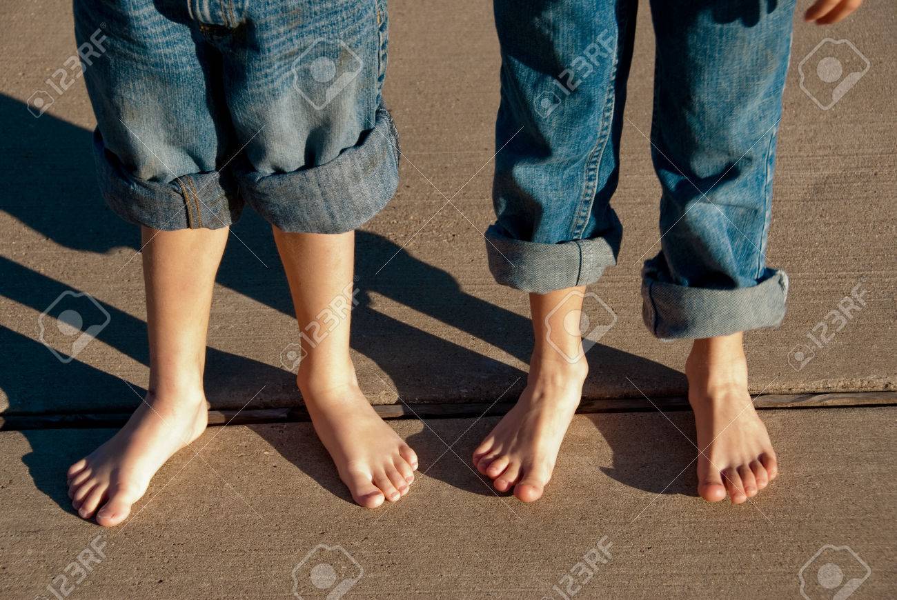 Dos Niños Con Los Pies Descalzos Y Los Pantalones Enrollados Pie Sobre La  Acera. Fotos, Retratos, Imágenes Y Fotografía De Archivo Libres De Derecho.  Image 54142657.