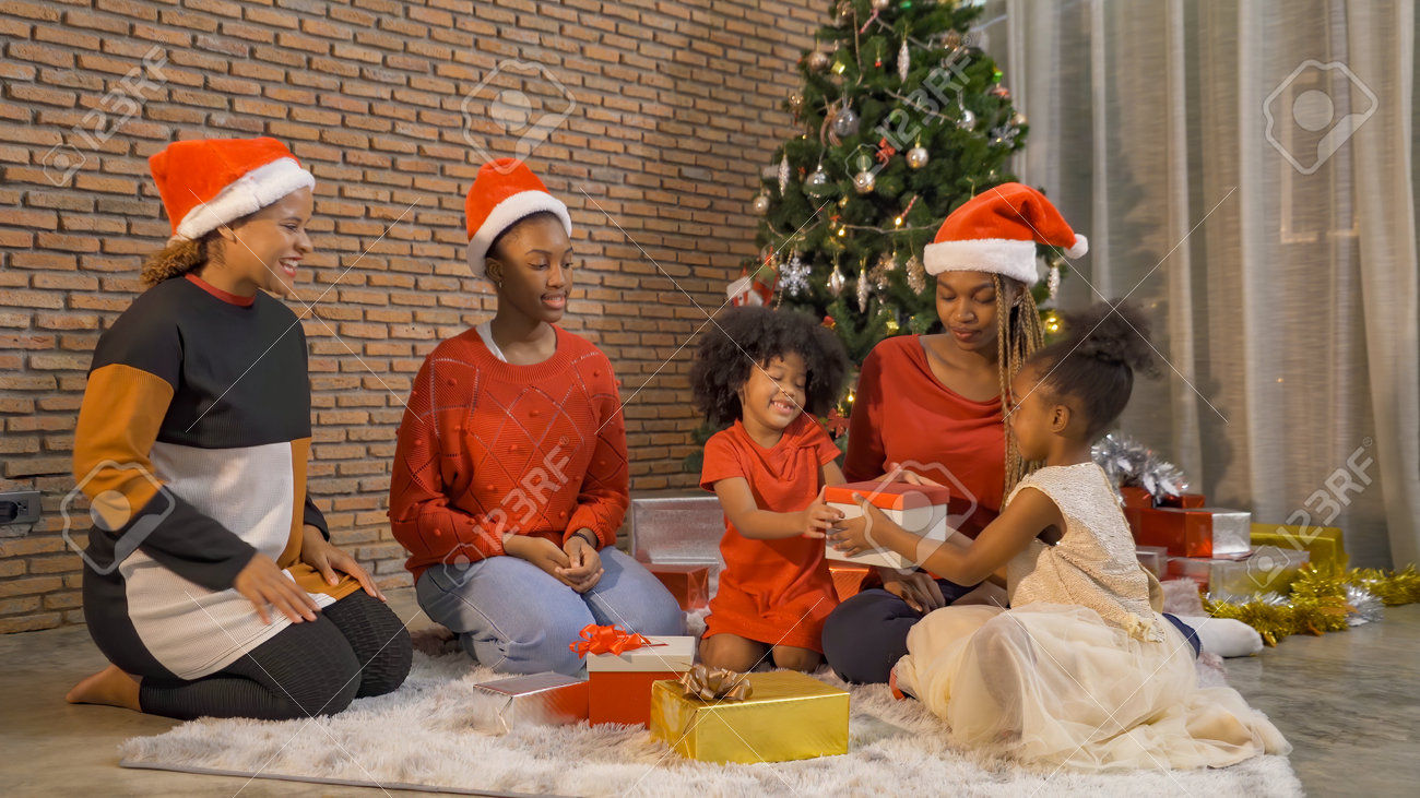 African American black family, women and kid girl daughters sharing gifts on Merry Christmas Eve Xmas Party. Celebration together at home. People lifestyle. Santa Claus. - 160854505 African American black family, women and kid girl daughters sharing gifts on Merry Christmas Eve Xmas Party. Celebration together at home. People lifestyle. Santa Claus. - 160854505