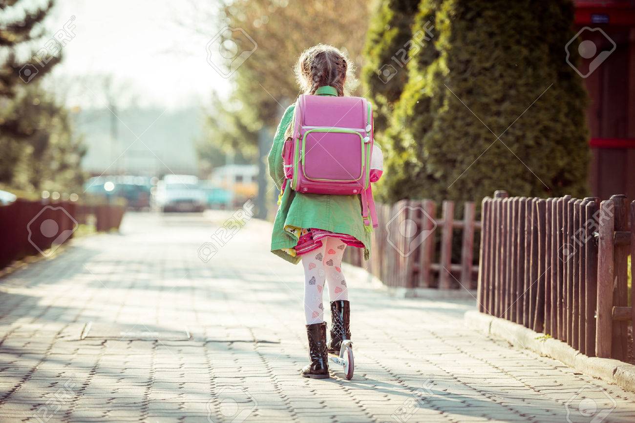 girl goes to school on a scooter. back view - 43021401 girl goes to school on a scooter. back view - 43021401