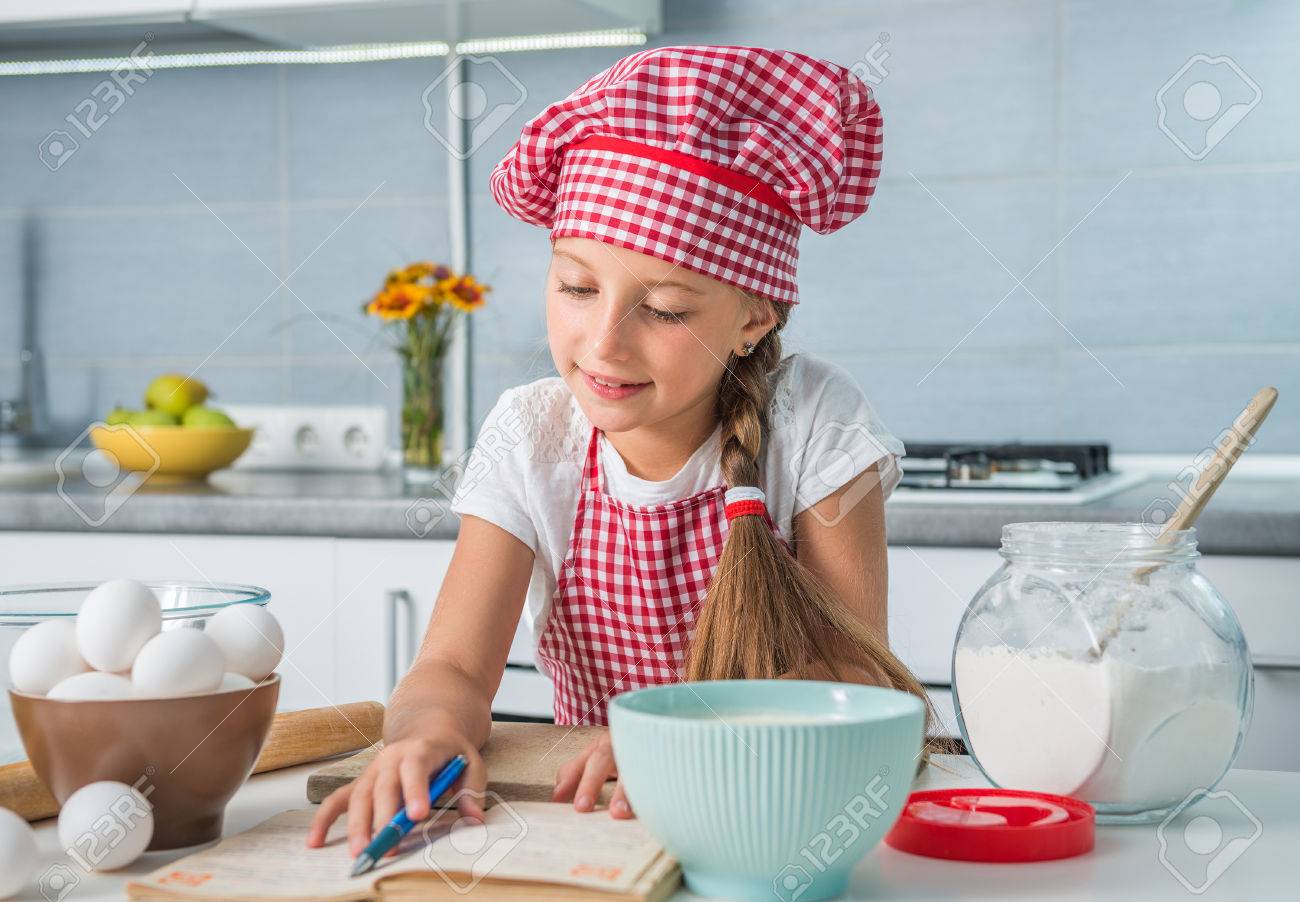 little girl baker reading a recipe on kitchen - 43785620 little girl baker reading a recipe on kitchen - 43785620