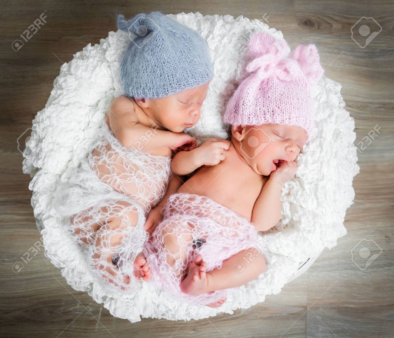 newborn twins - a boy and a girl sleeping in a basket - 43785640 newborn twins - a boy and a girl sleeping in a basket - 43785640