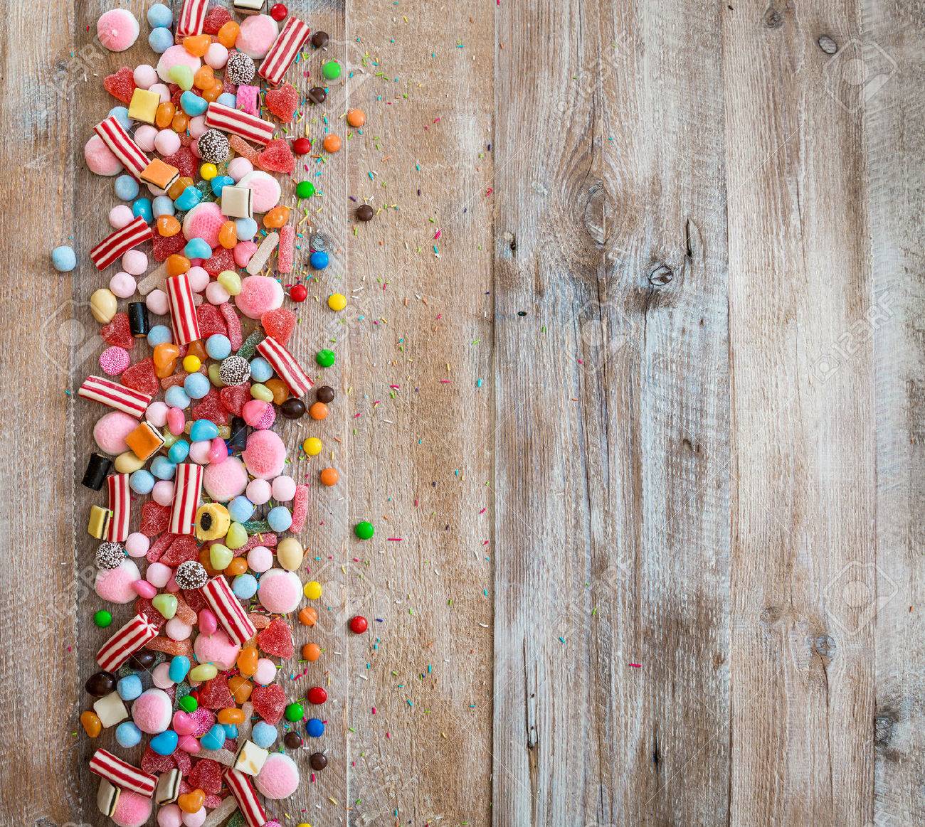 variety of candies on a wooden background with space for text - 46656026 variety of candies on a wooden background with space for text - 46656026