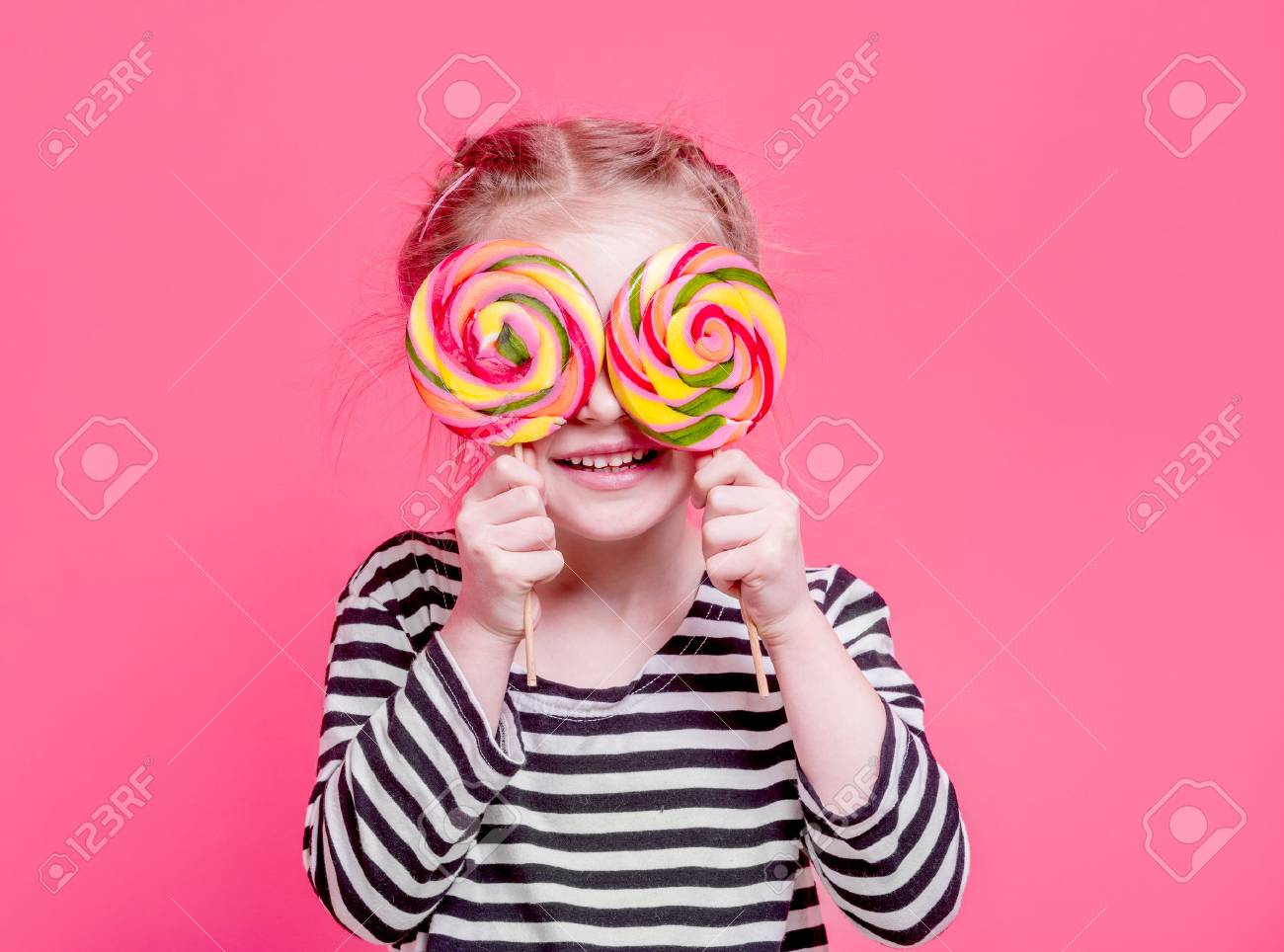 Kid girl with lollypops in front her eyes - 94571133 Kid girl with lollypops in front her eyes - 94571133
