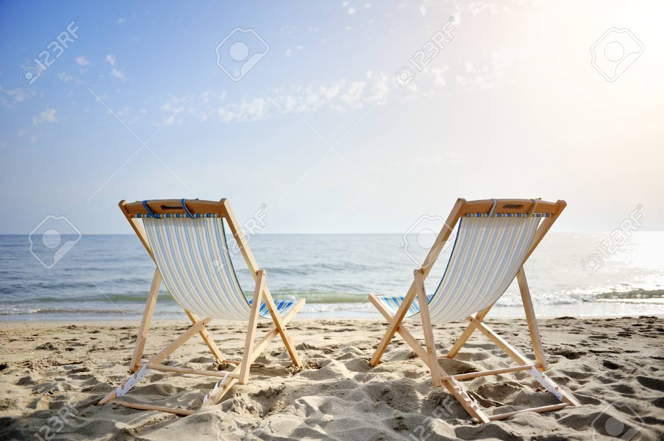 couple of chairs on sandy beach at sunset looking for the blue sea - relaxation concept - 29815272 couple of chairs on sandy beach at sunset looking for the blue sea - relaxation concept - 29815272