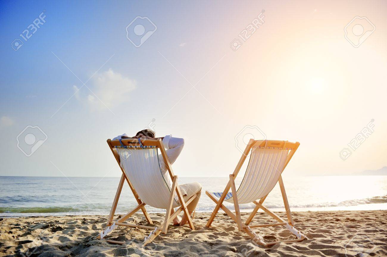 man on the beach relaxing on deck chair waiting for his girlfriend - 30534228 man on the beach relaxing on deck chair waiting for his girlfriend - 30534228