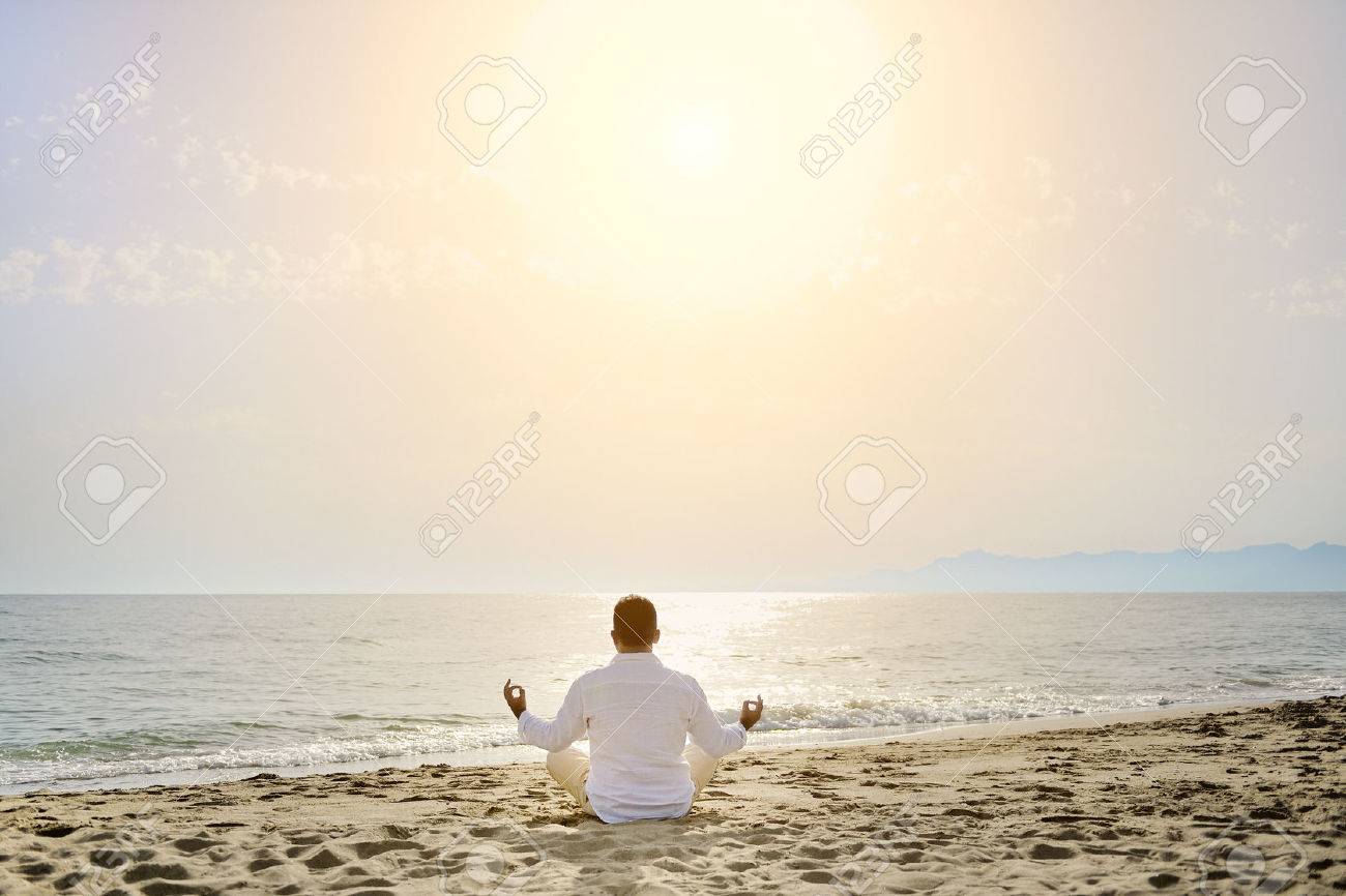 man doing yoga meditation exercises on the beach at sunset- healthy lifestyle concept - 30538562 man doing yoga meditation exercises on the beach at sunset- healthy lifestyle concept - 30538562