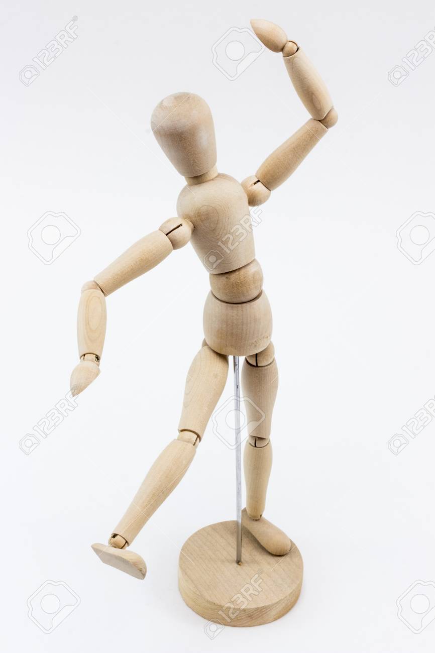 a wooden mannequin in a dance pose on it s stand on a white