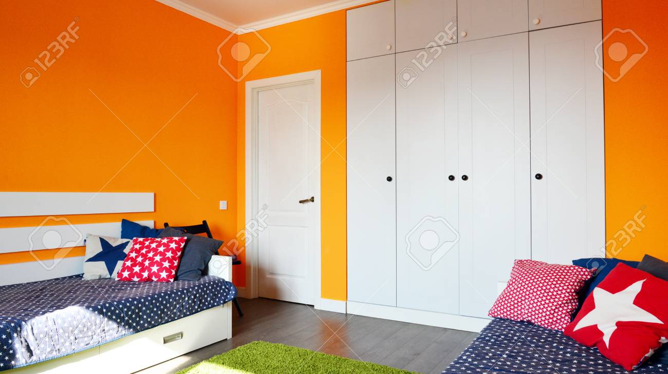 Kids Bedroom In Orange And Blue Colors With Two Beds And Built In