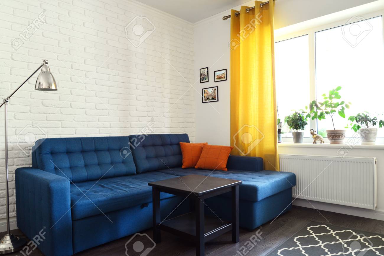 青いソファ 白レンガ壁と黄色のカーテンときれいなファミリールーム デザイン インテリアの概念 の写真素材 画像素材 Image