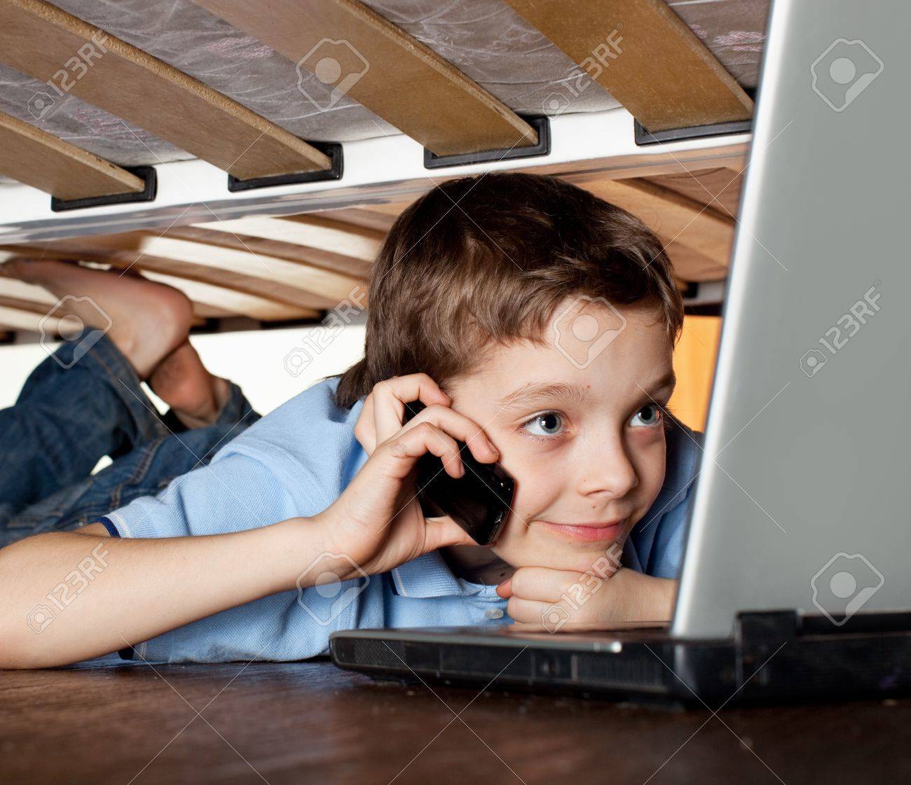 ベッドの下にノート パソコンを遊ぶ子 パソコン依存症 の写真素材 画像素材 Image